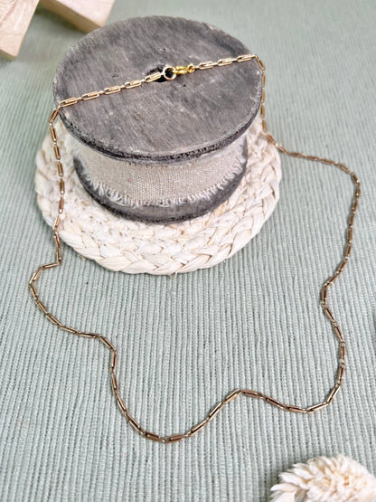 A gold paperclip link chain necklace