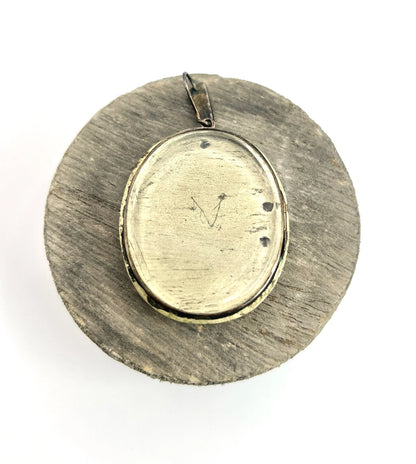 An antique oval silver locket