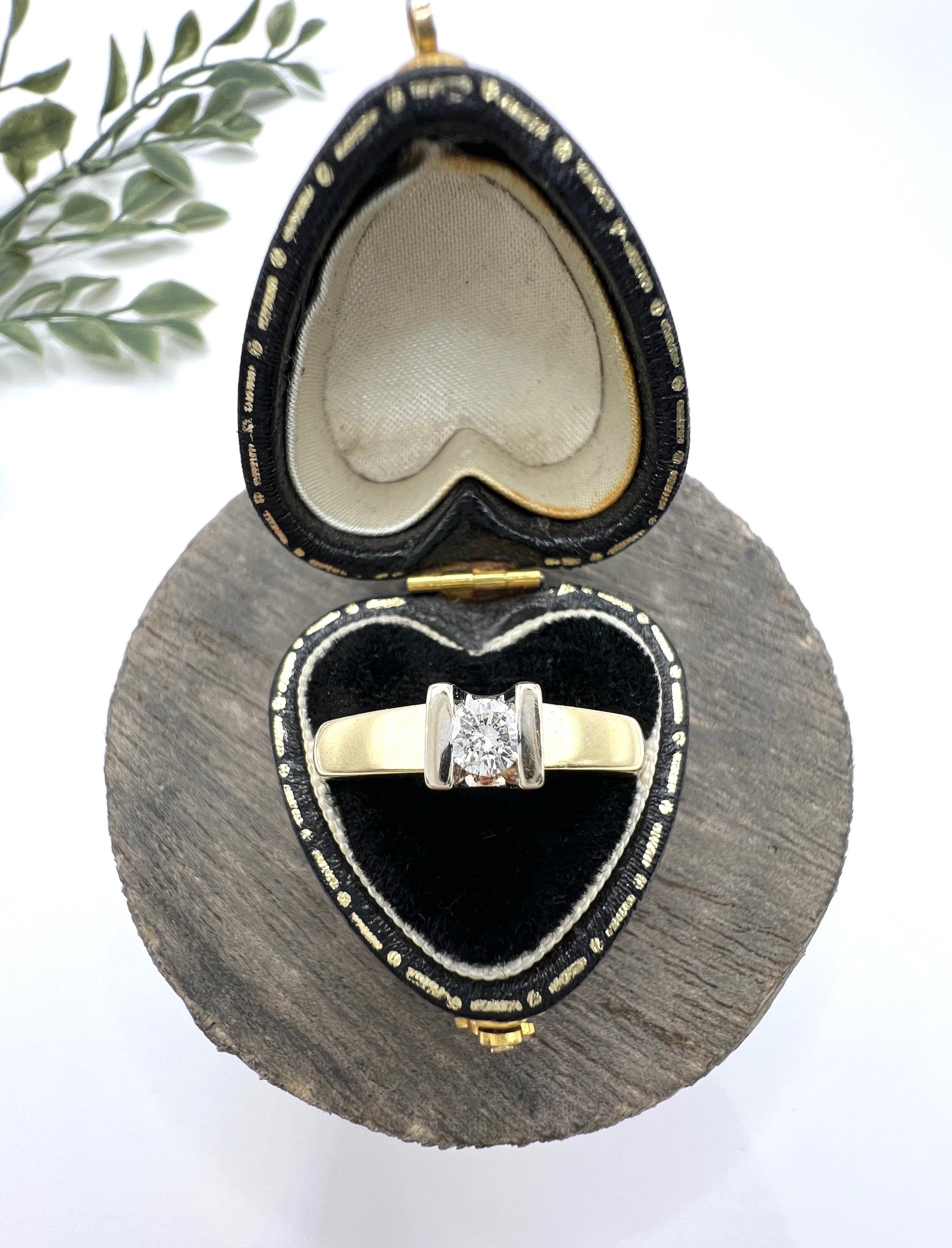 A brilliant cut diamond solitaire ring in yellow gold, in a heart-shaped ring box