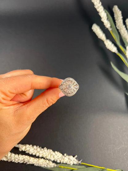 A diamond cocktail ring in yellow and white metal held by a hand