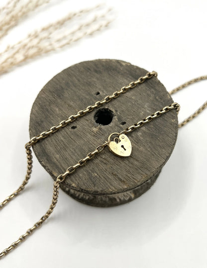 A gold belcher link chain with a heart shaped padlock clasp pendant