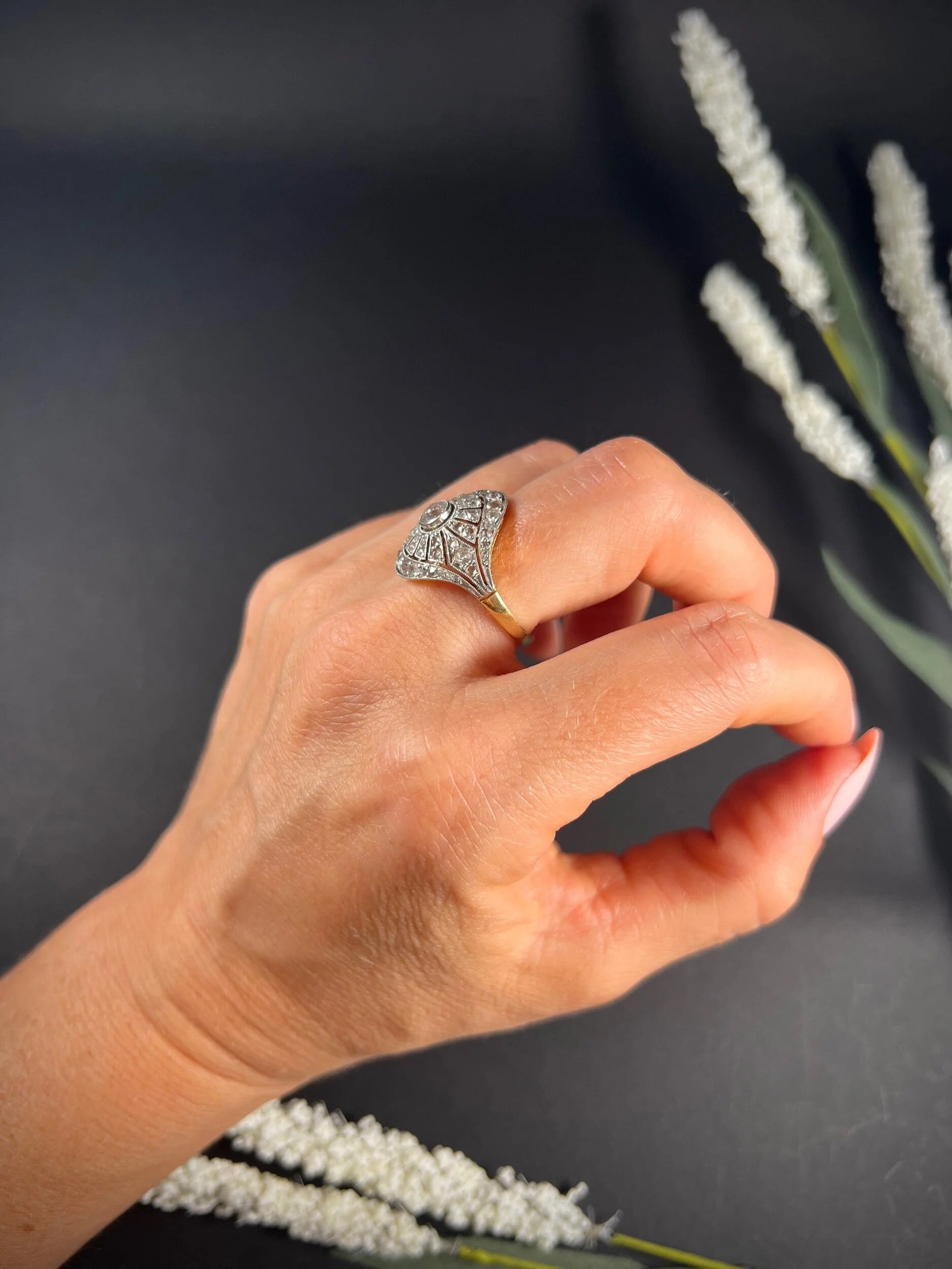 A diamond cocktail ring in yellow and white metal modelled on a hand