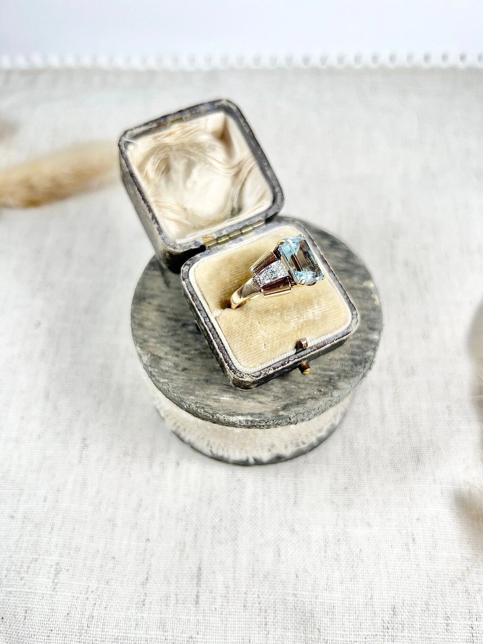 An aquamarine and diamond cocktail ring in gold, in an antique ring box