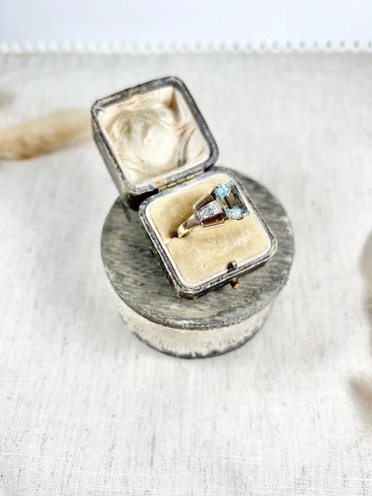 An aquamarine and diamond cocktail ring in gold, in an antique ring box