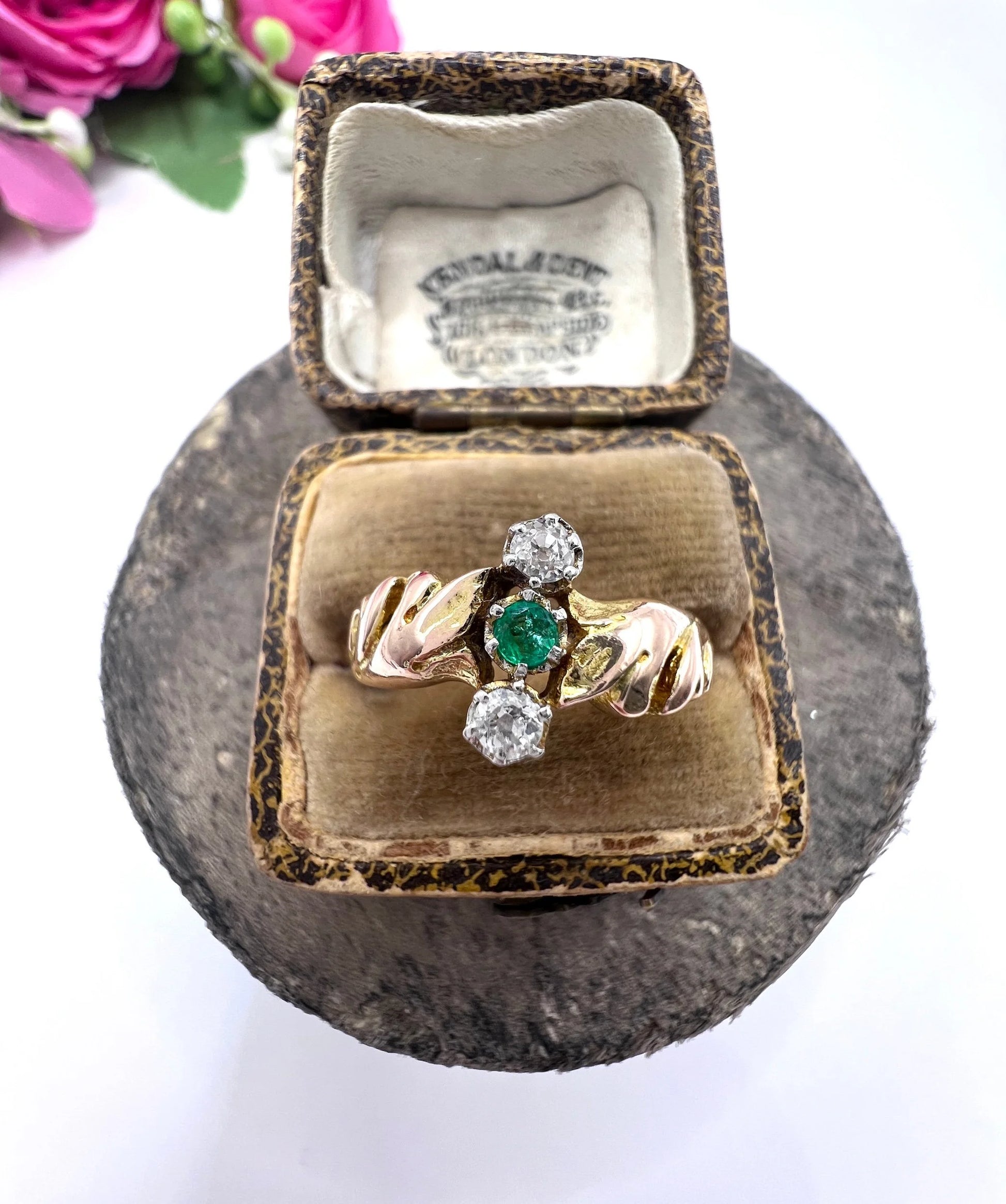 A three stone emerald and diamond ring in yellow and white gold, in an antique ring box