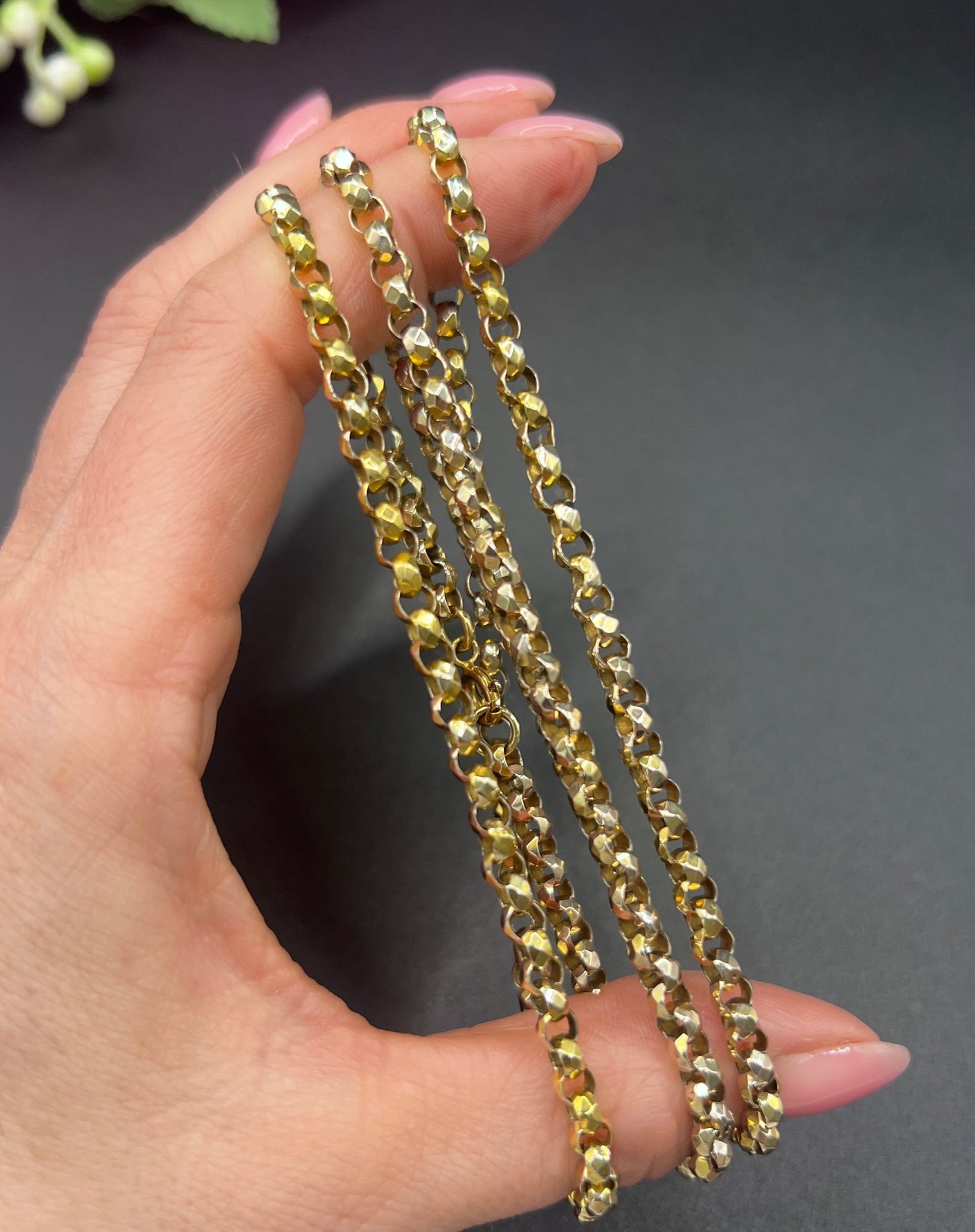 A yellow gold belcher link chain necklace, held in a hand