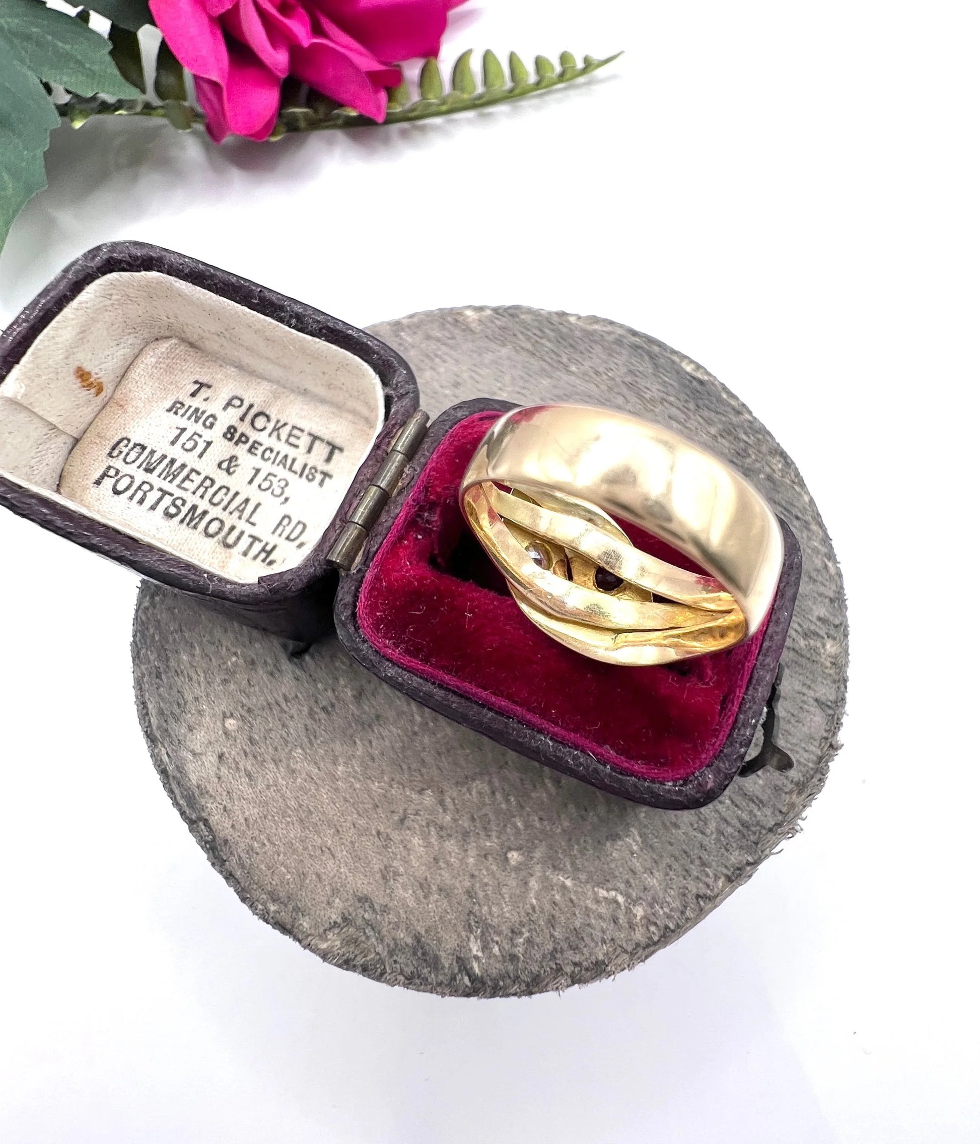 A yellow gold double headed snake ring with a ruby and a diamond, in a ring box