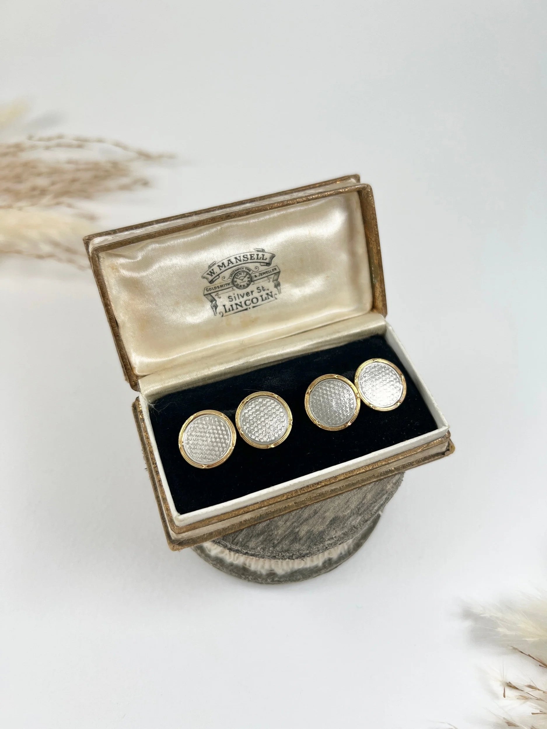 A pair of circular platinum and yellow gold cufflinks, in an antique box