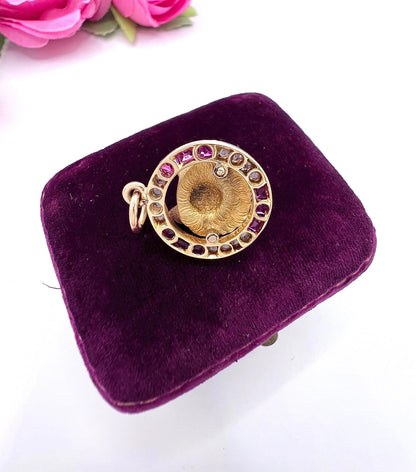 A fox head pendant in yellow gold with a ruby and diamond border