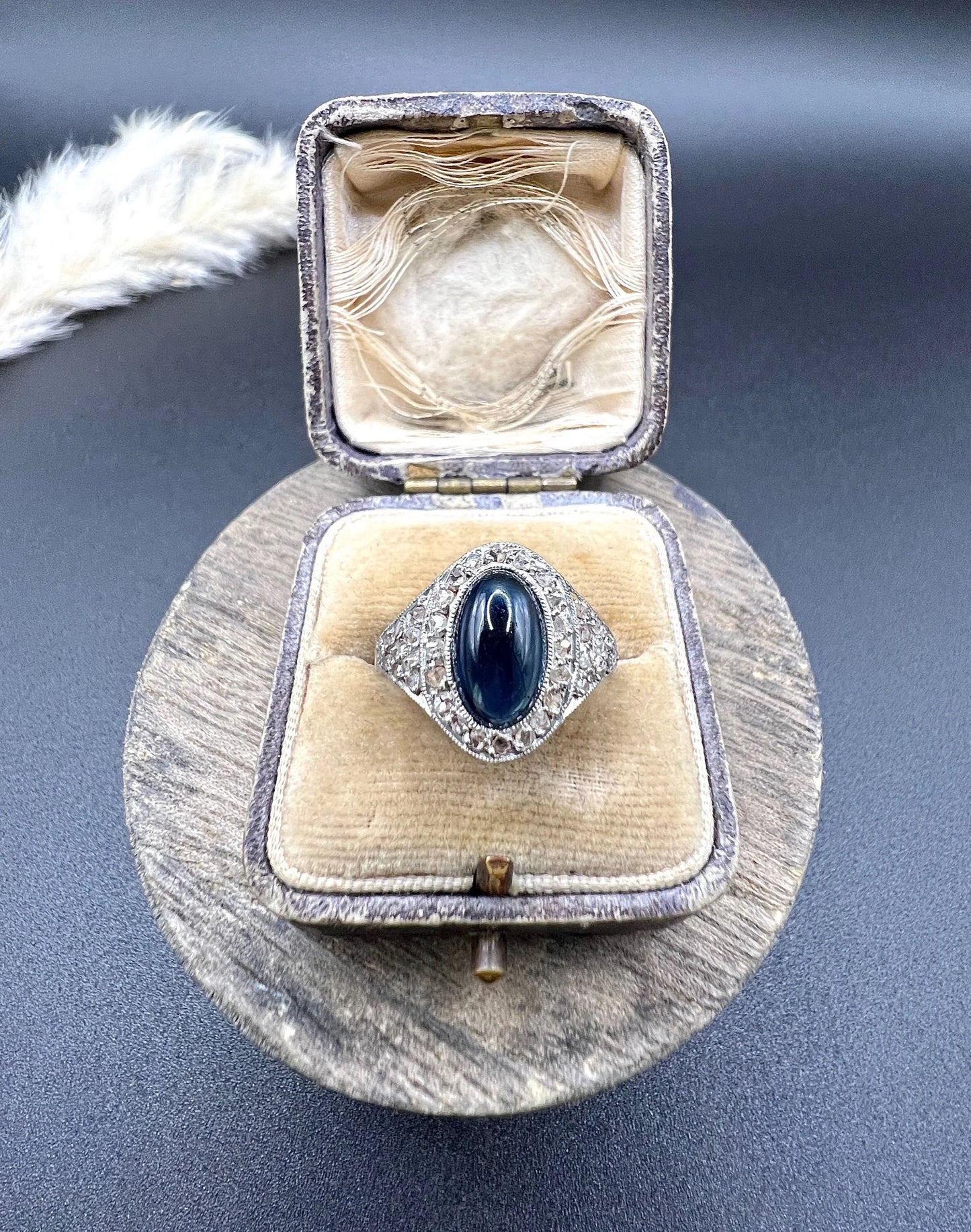 An oval cabochon sapphire and diamond fancy cluster ring in yellow and white gold, in a ring box