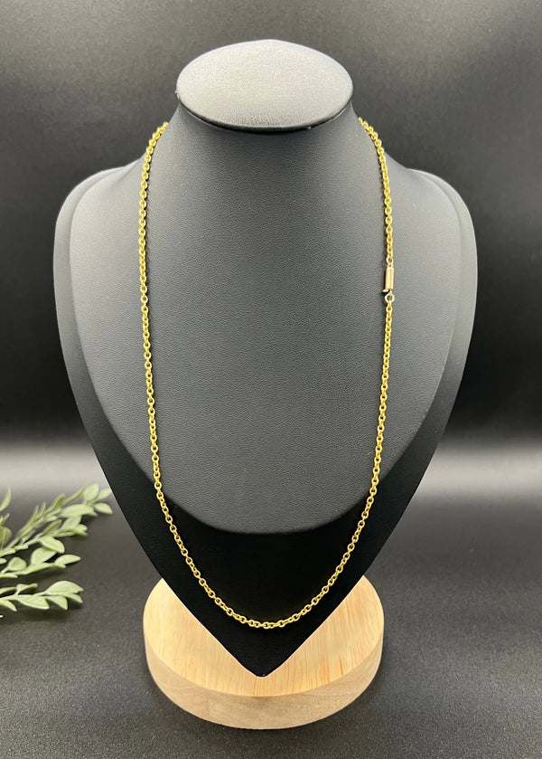 A yellow gold trace link chain necklace, on a black jewellery bust