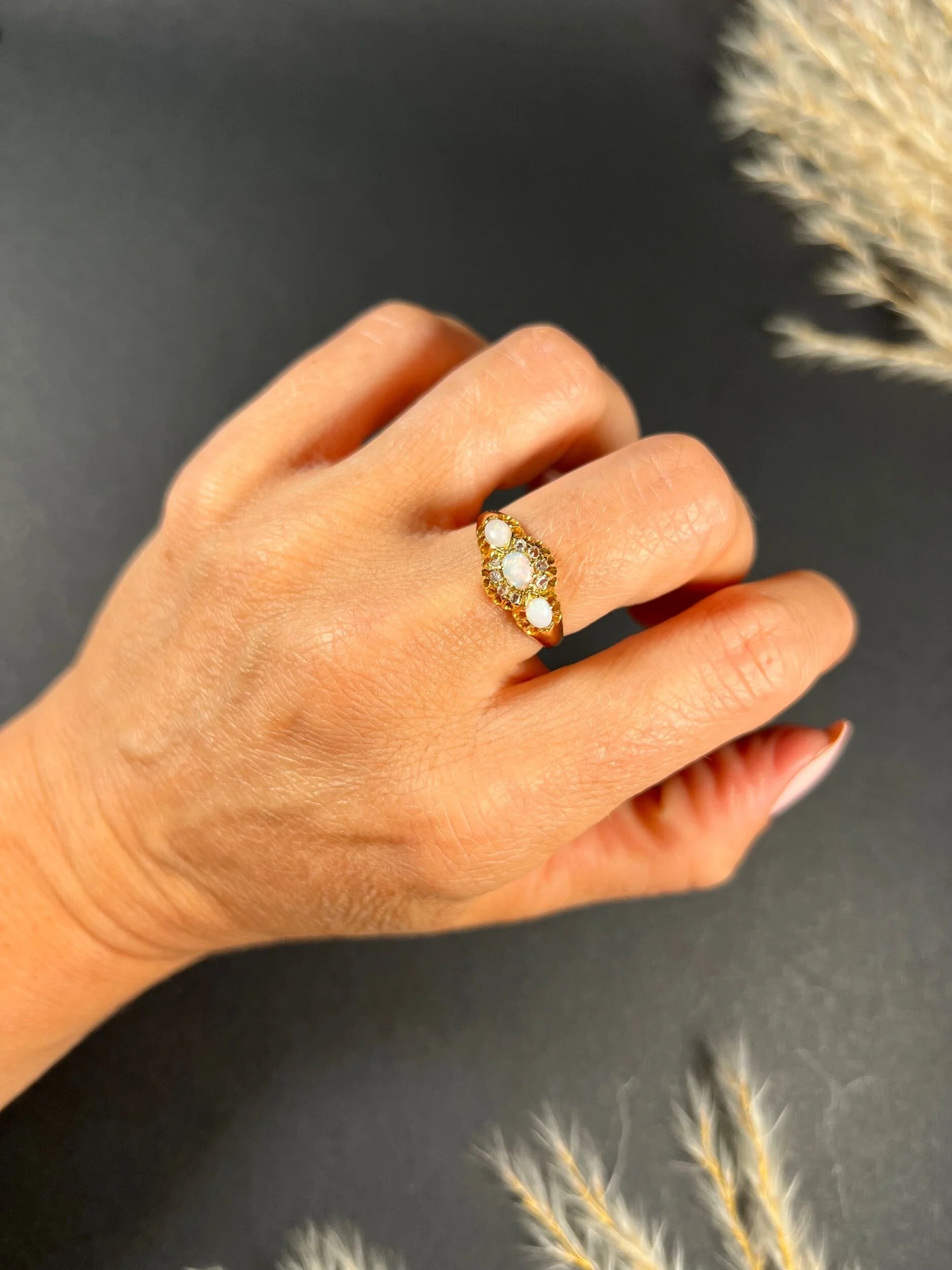 A yellow gold opal and diamond dress ring, modelled on a hand