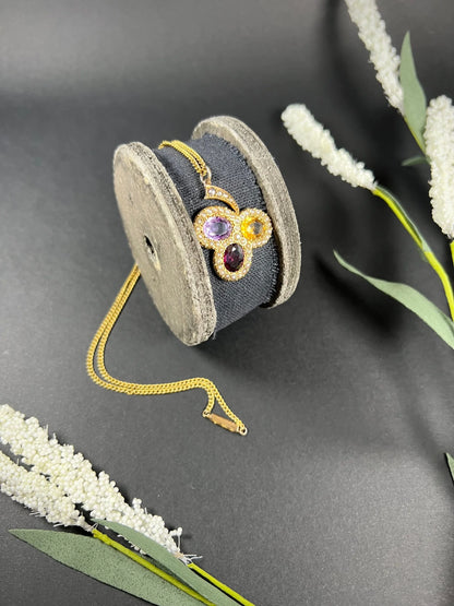 A yellow gold clover pendant with amethyst, citrine, garnet and seed pearls, with a chain