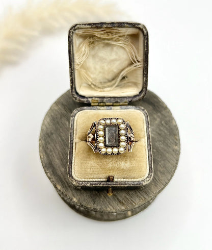 An antique seed pearl mourning ring in gold, in a ring box