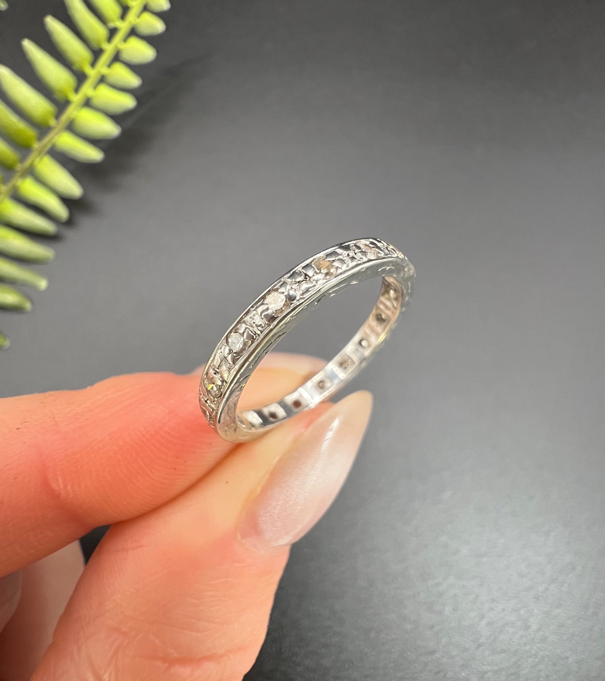 A diamond full eternity ring in white gold, held in a hand