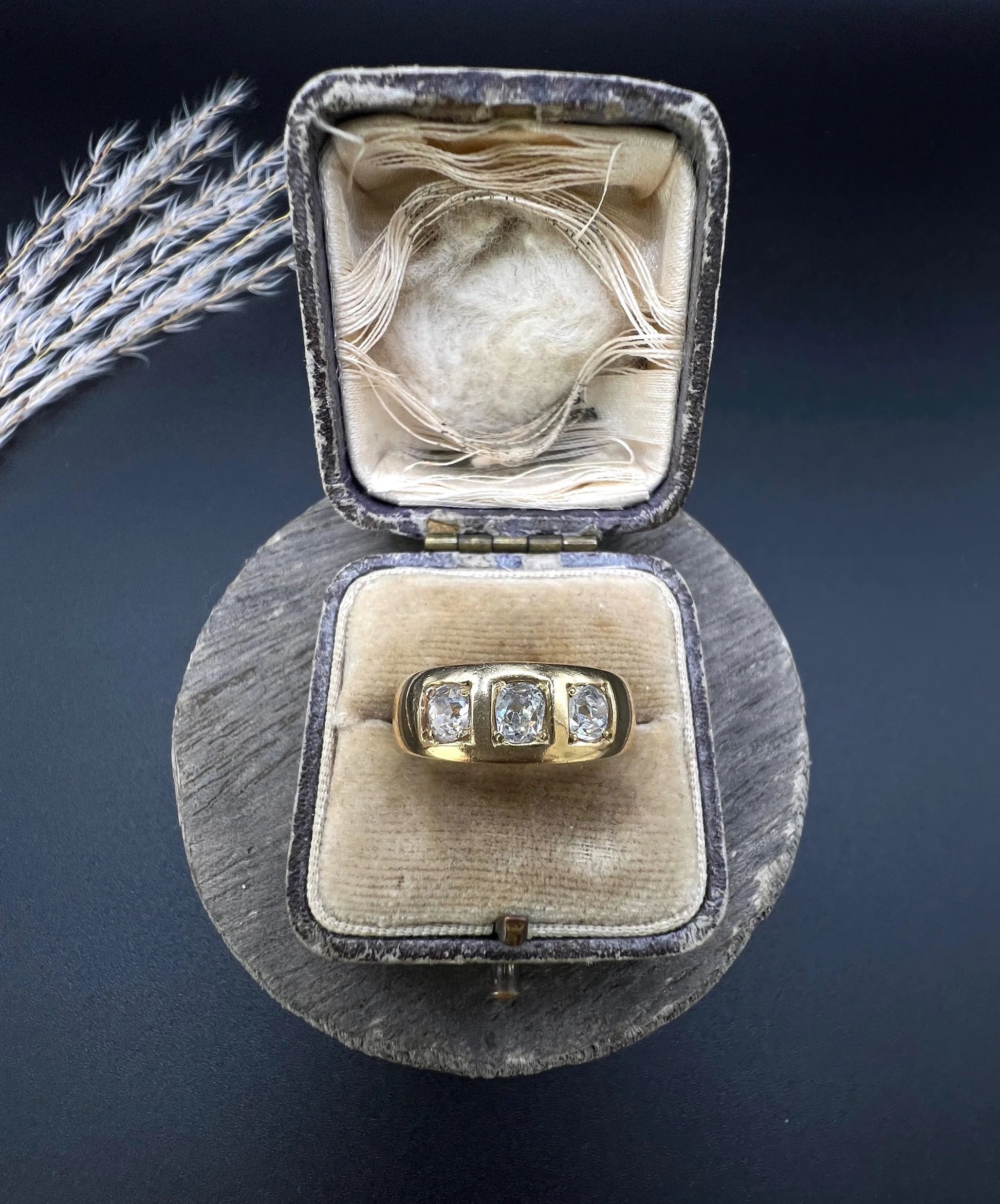 A three stone old cut diamond ring in yellow gold, in an antique ring box