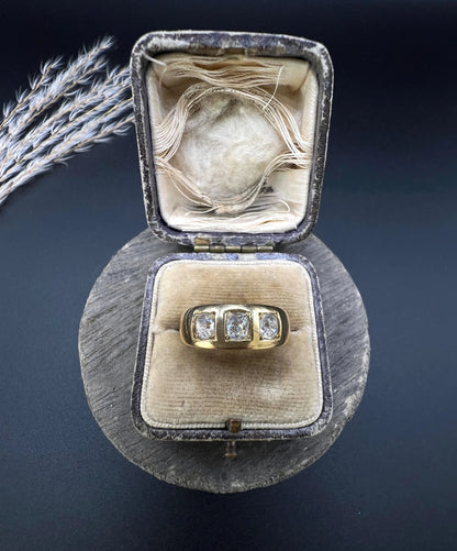 A three stone old cut diamond ring in yellow gold, in an antique ring box