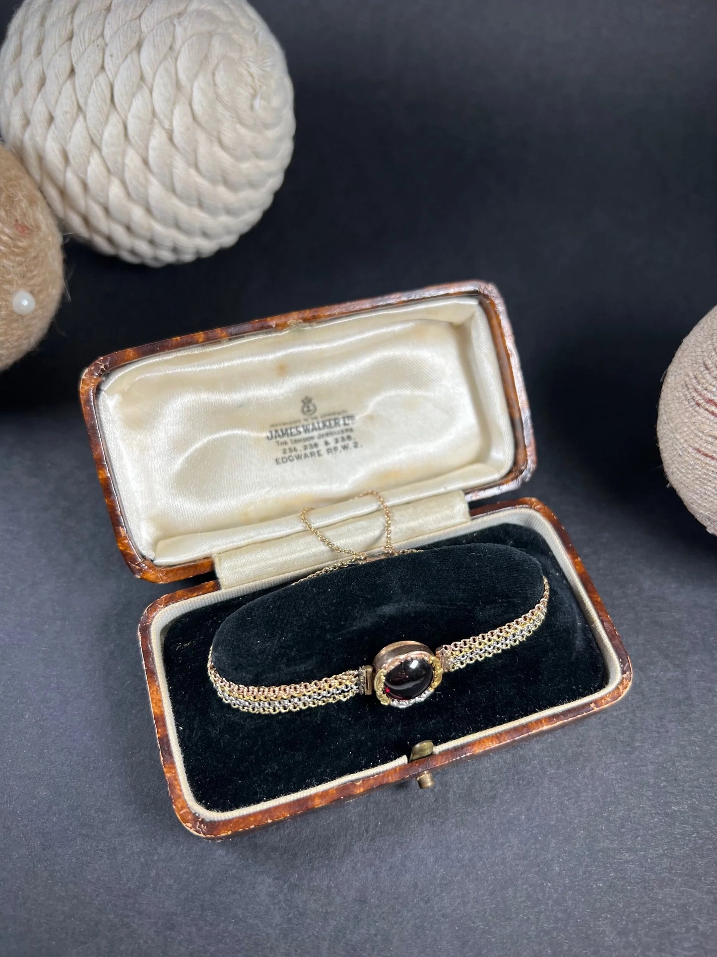 A cabochon garnet bracelet with three colour gold chains, in an antique box