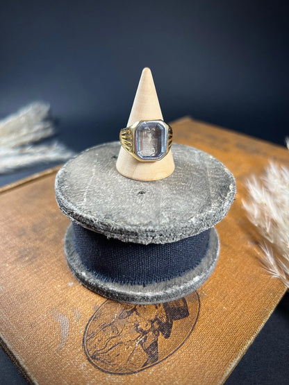 A yellow gold blue glass intaglio signet ring, on a ring cone