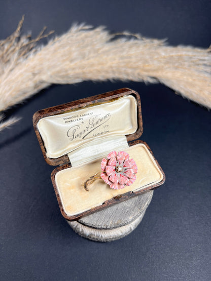 A pink enamelled flower brooch with a diamond centre, in yellow gold, in a box
