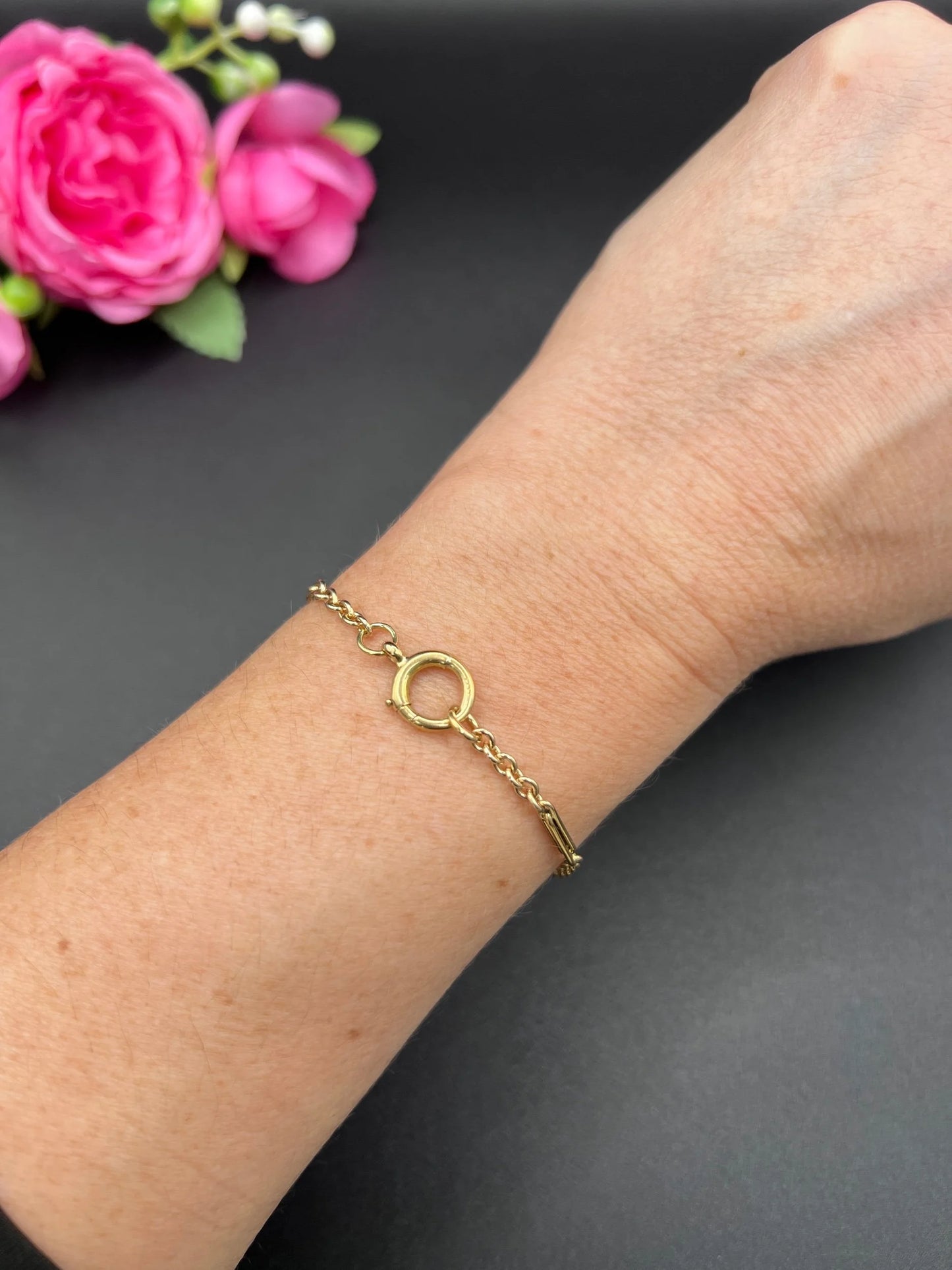 A yellow gold chain link bracelet with a bolt ring clasp, modelled on a wrist