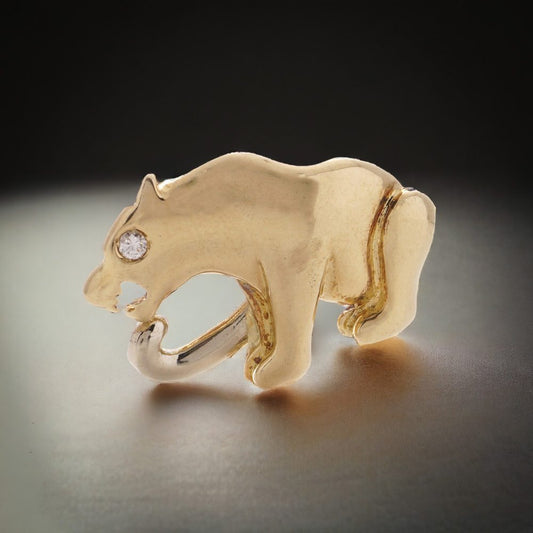 Sitting panther brooch with diamond eye in gold. 