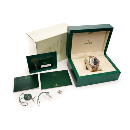 A Rolex Yacht-Master black dial wristwatch in steel and rose gold, with box and papers, on a white background