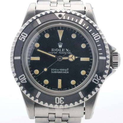 A Rolex Submariner wristwatch in stainless steel with a black dial, on a white background