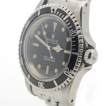 A Rolex Submariner wristwatch in stainless steel with a black dial and jubilee bracelet, on a white background