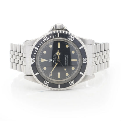 A Rolex Submariner wristwatch in stainless steel with a black dial and jubilee bracelet, on a white background