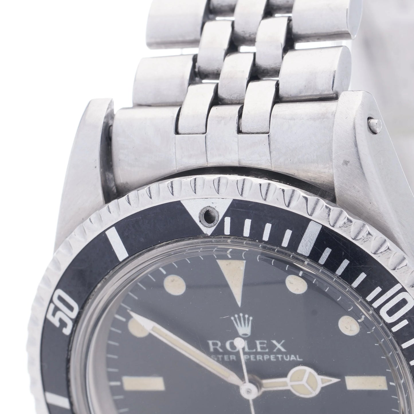 A Rolex Submariner wristwatch in stainless steel with a black dial and jubilee bracelet, on a white background
