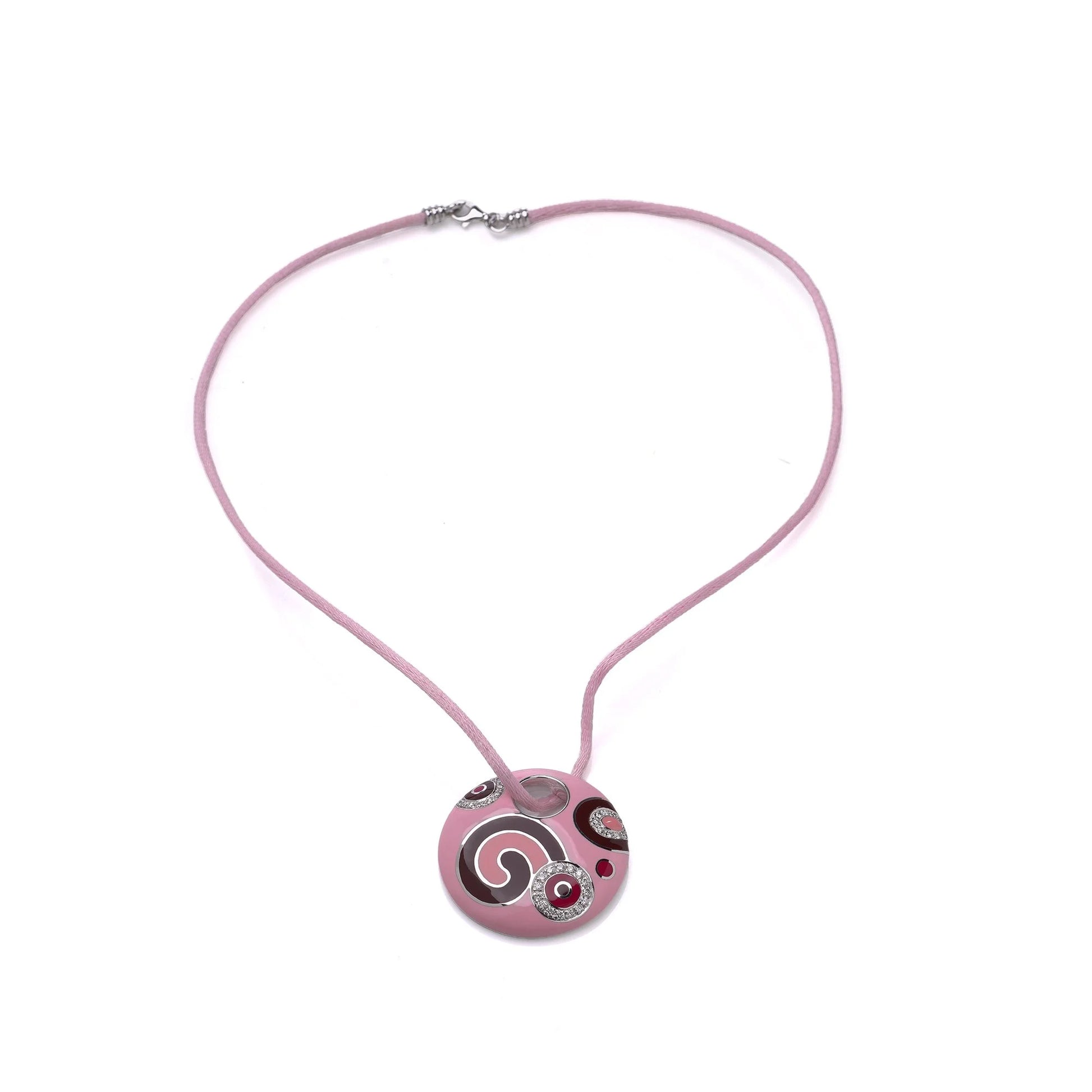 A pink enamel circular pendant with diamonds on a pink cord, on a white background