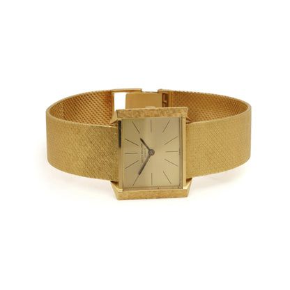 A yellow gold Patek Phillipe wristwatch with integrated bracelet, on a white background