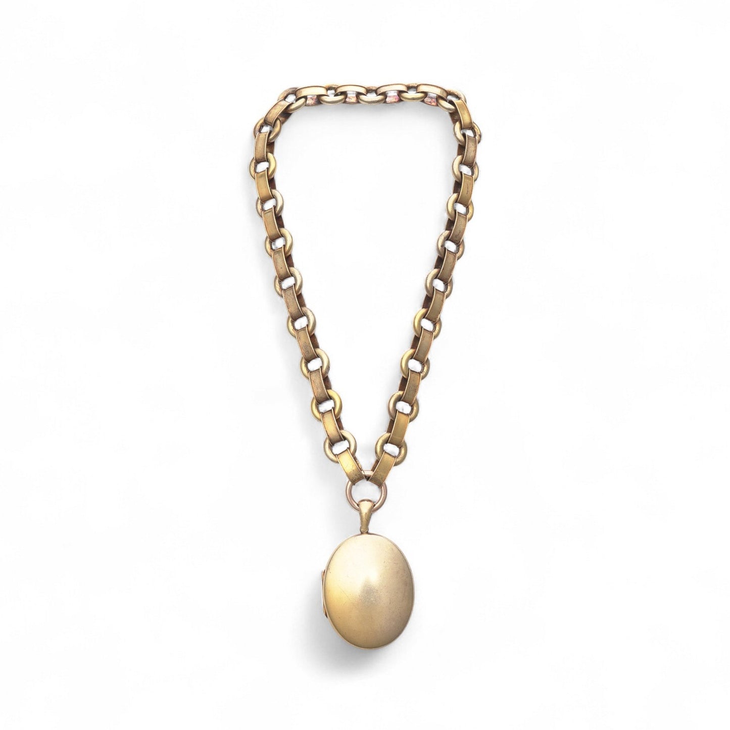 An antique yellow and rose gold fancy link necklace with an oval locket pendant, on a white background