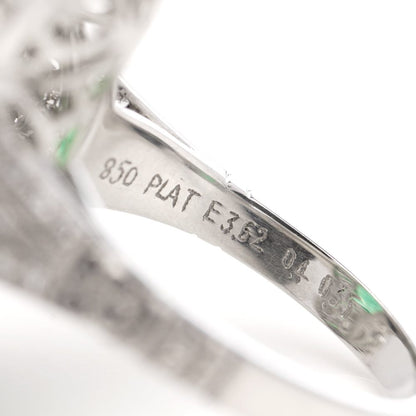 Oval cut emerald ring surround by emeralds and diamonds set in platinum.