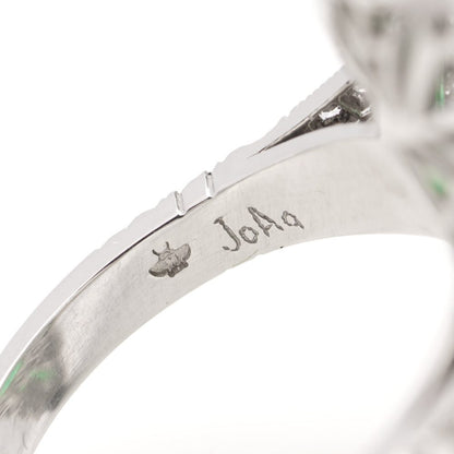 Oval cut emerald ring surround by emeralds and diamonds set in platinum.