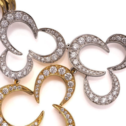 Gold necklace with three flower head pendants set with diamonds.