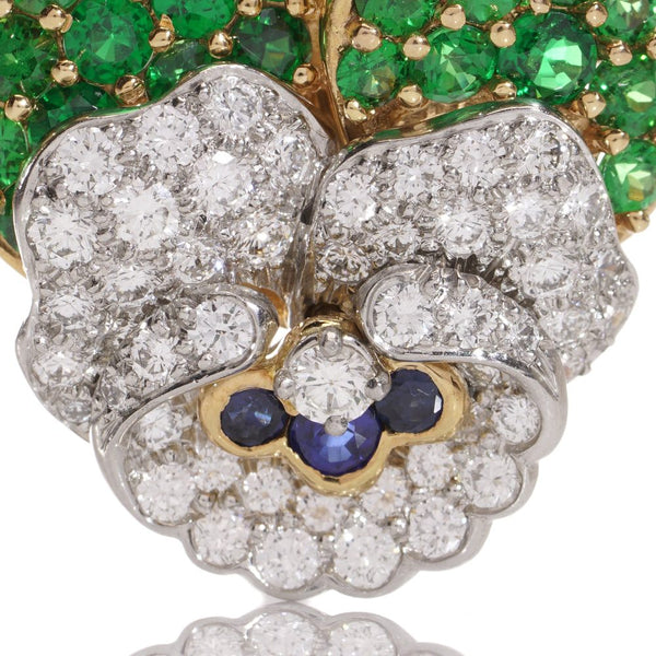 Tiffany & Co brooch in gold and platinum with tsavorite garnets, diamonds, and sapphires.