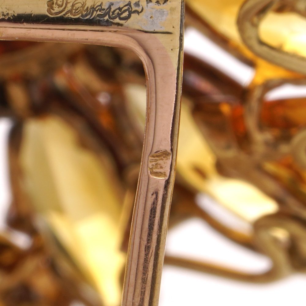 Gold sunflower brooch with garnet, topaz and diamonds.