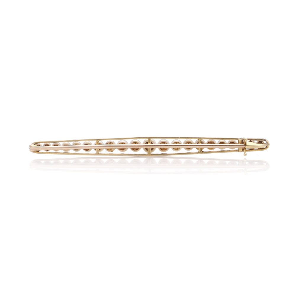 Gold and platinum elongated brooch adorned with pearls