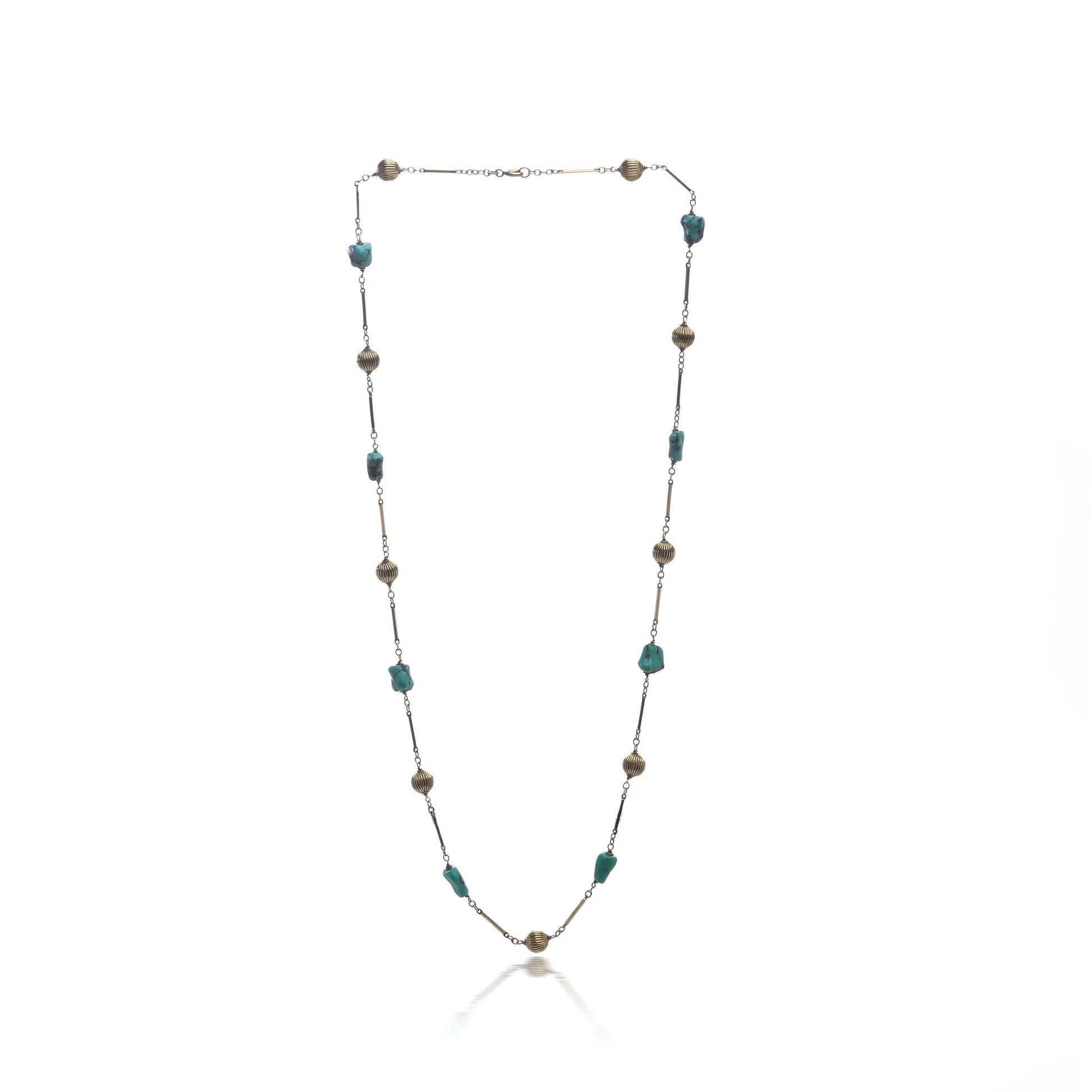A yellow gold long chain necklace with turquoise nuggets, on a white background