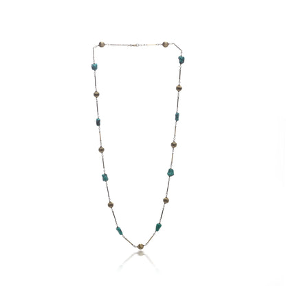 A yellow gold long chain necklace with turquoise nuggets, on a white background