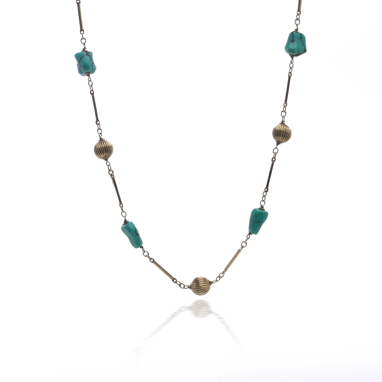 A yellow gold long chain necklace with turquoise nuggets, on a white background