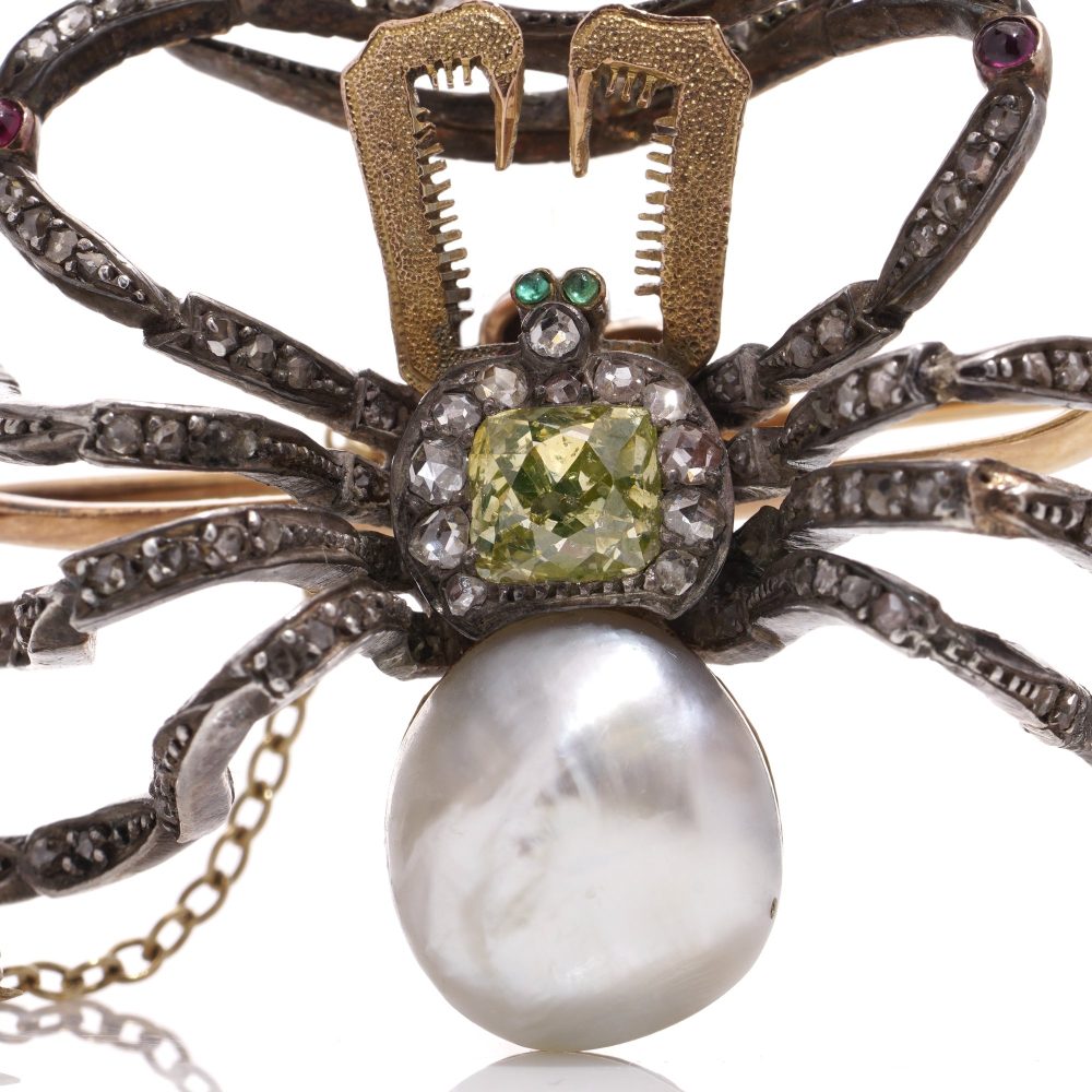 Antique spider brooch with diamonds, pearl, rubies and emeralds in gold and silver.