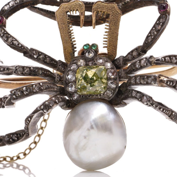 Antique spider brooch with diamonds, pearl, rubies and emeralds in gold and silver.