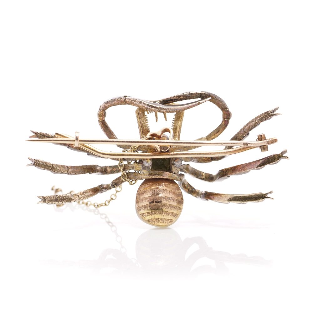 Antique spider brooch with diamonds, pearl, rubies and emeralds in gold and silver.
