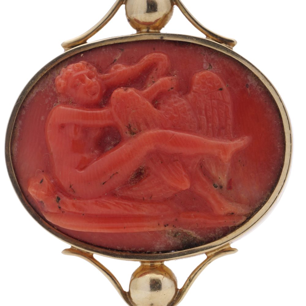 Victorian pocket watch key/pendant in gold and carved coral showing neoclassical scenes.