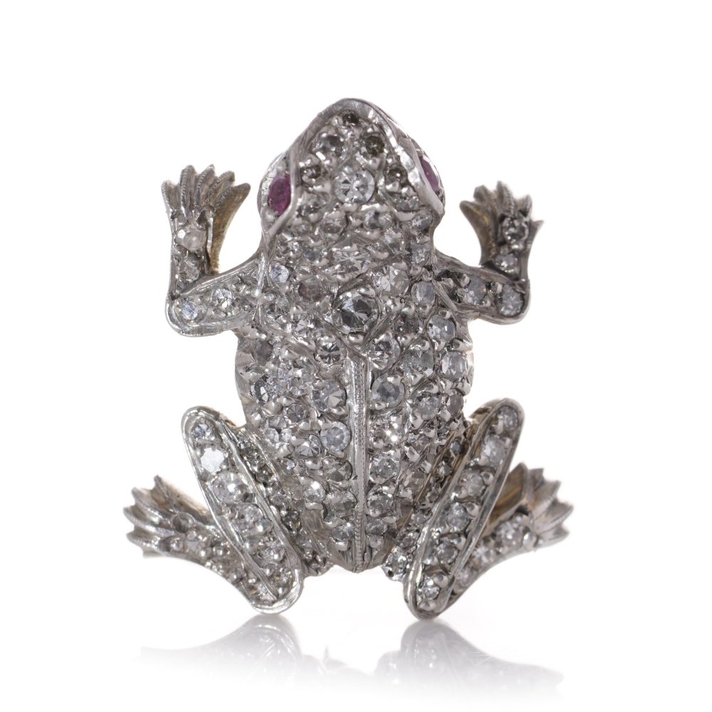 An Edwardian frog brooch in gold and silver set with diamonds and rubies.