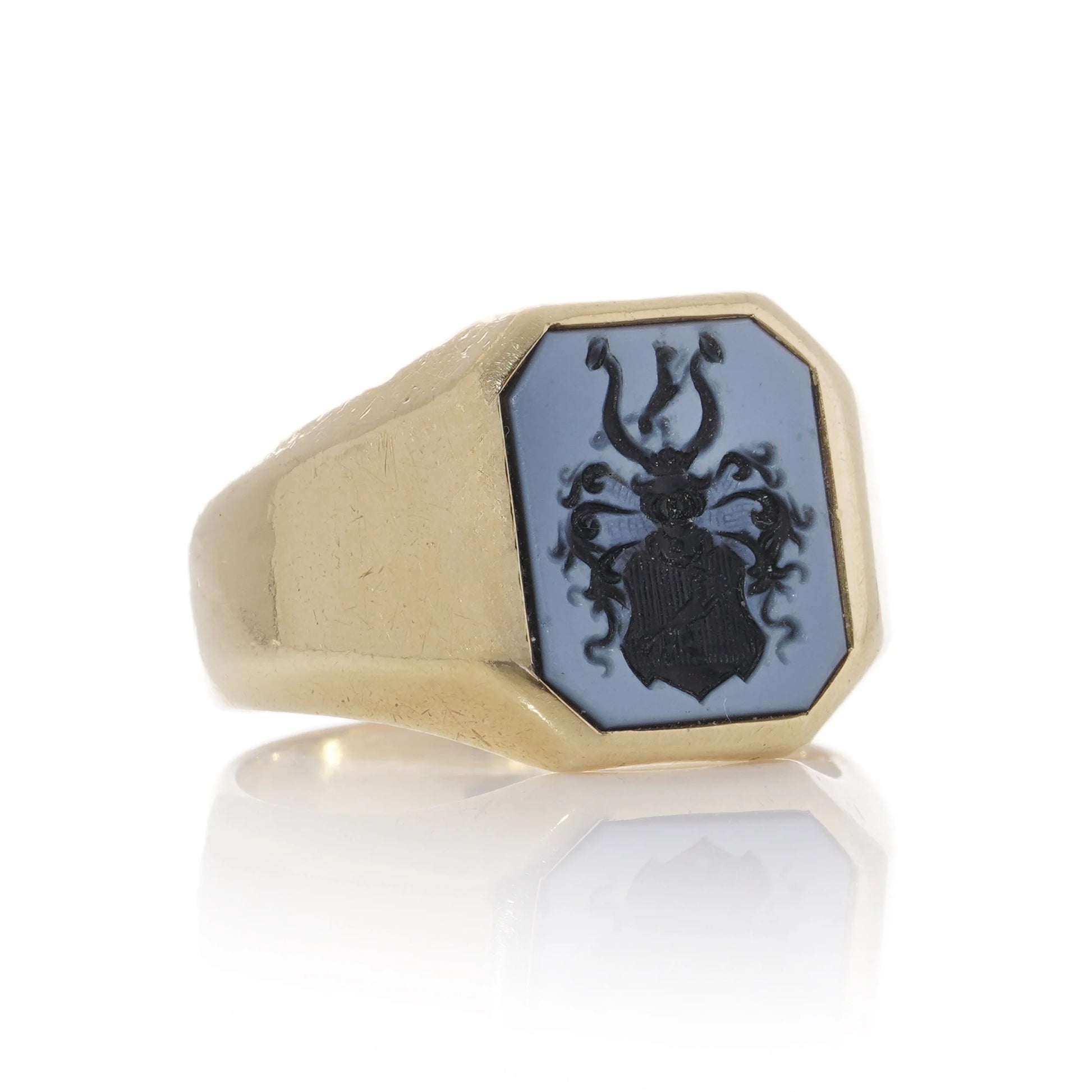 A yellow gold ring with an octagonal sardonyx intaglio, on a white background