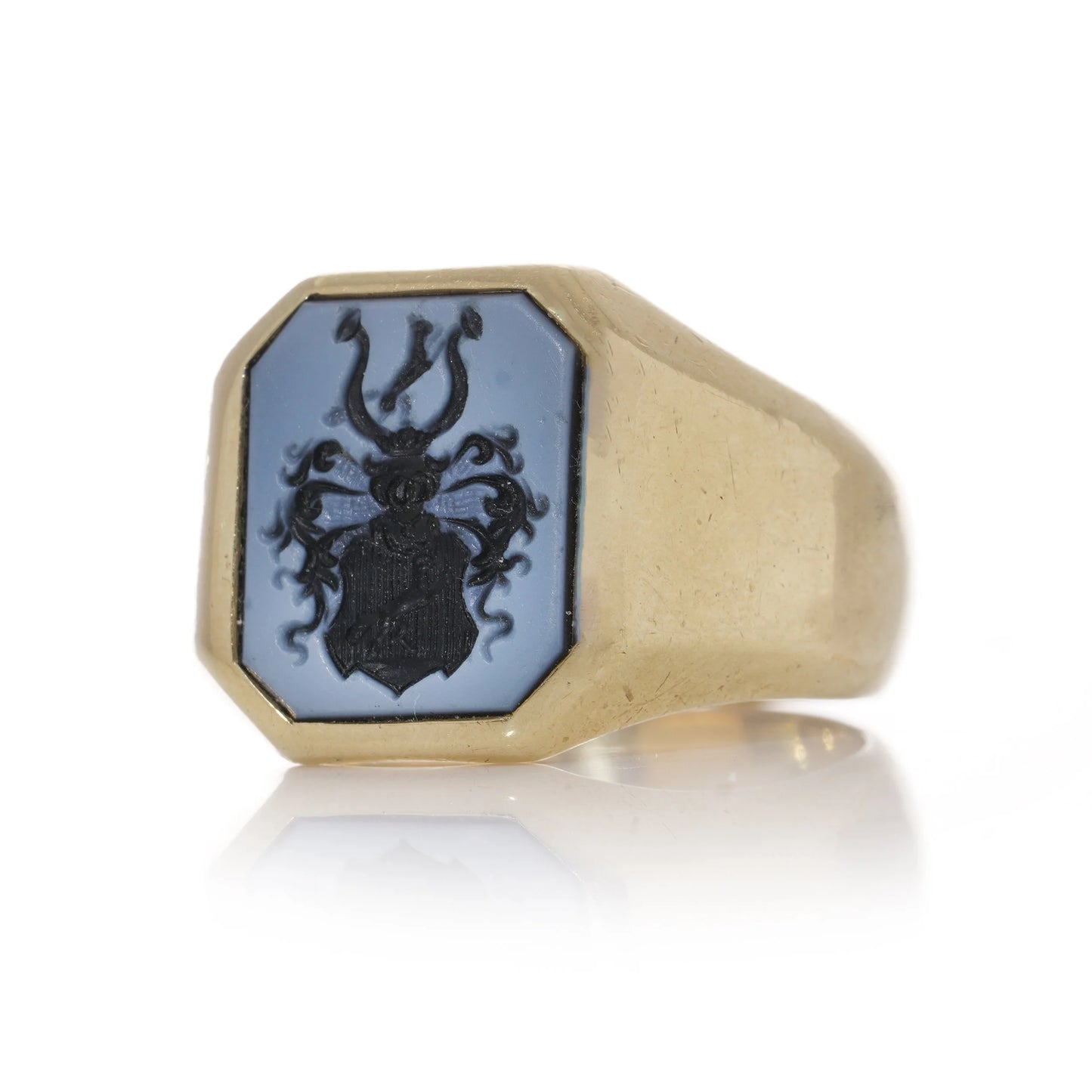 A yellow gold ring with an octagonal sardonyx intaglio, on a white background